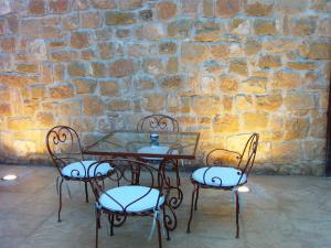 einen Tisch und vier Stühle vor einer Ziegelwand in der Unterkunft Hotel Villa Monter in Alcañiz