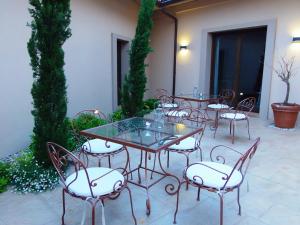 Hotel Villa Monter في الكانيز: مجموعة من الطاولات والكراسي في الفناء