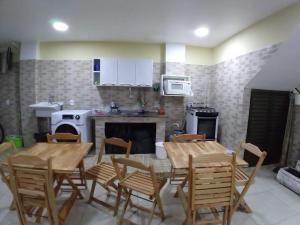 a kitchen with wooden tables and chairs in a kitchen at Pousada Ninho da Coruja in Arraial do Cabo