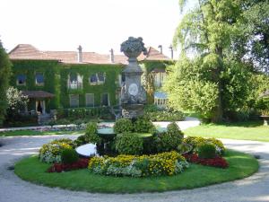 um jardim em frente a uma casa com uma estátua em Casa dos Bisavós- Slow Down na rota do Românico no Porto