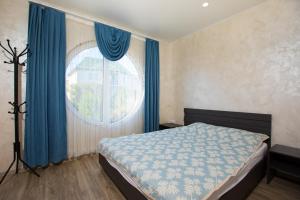 チョロノモスクにあるApartamenty Terrasaのベッドルーム1室(ベッド1台、青いカーテン付きの窓付)