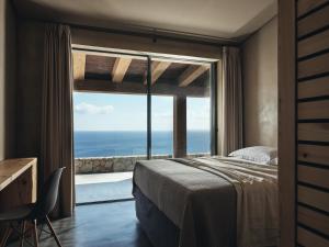 a bedroom with a bed and a large window at Vais Luxury Villas in Agios Nikolaos