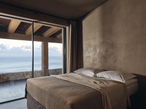 a bedroom with a bed and a large window at Vais Luxury Villas in Agios Nikolaos