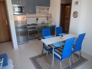 Una cocina con una mesa de comedor y sillas azules. en Adriatic Arteon, en Baška