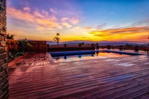 a pool on a deck with a sunset in the background at Peponi Living Spaces in Kigali