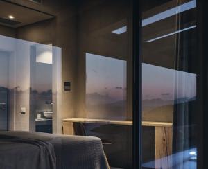 a bedroom with glass doors with a view of a bed at Vais Luxury Villas in Agios Nikolaos