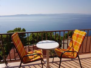 two chairs and a table on a balcony with the ocean at Apartment Danica in Brela