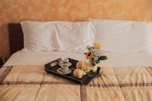 bandeja con comida y flores en una cama en B&B Il Guado, en Voghenza