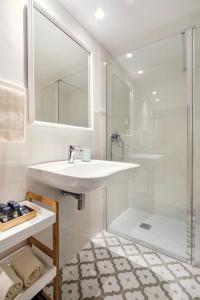 a white bathroom with a sink and a shower at Senda Caimari in Caimari