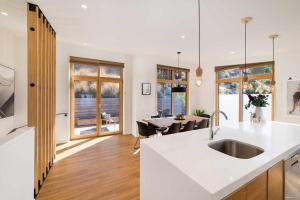 cocina con encimera blanca y mesa en The Lairds Bothy, en Queenstown