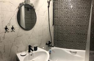 ウラジカフカスにあるОднокомнатная-двухуровневая квартираのバスルーム(洗面台、鏡付)