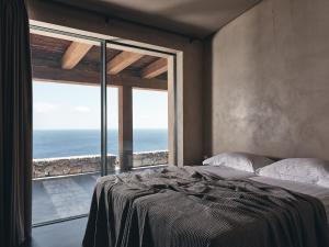 a bedroom with a bed with a view of the ocean at Vais Luxury Villas in Agios Nikolaos