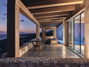 a balcony of a house with a table and chairs at Vais Luxury Villas in Agios Nikolaos