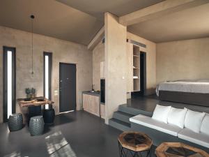 a bedroom with a bed and a couch and a table at Vais Luxury Villas in Agios Nikolaos