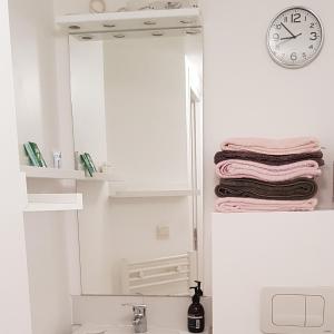 ein Badezimmer mit einem Spiegel und einem Waschbecken in der Unterkunft l’appart Malouin à 50M de la plage in Dunkerque