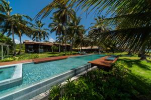 a swimming pool with a bench next to a house at Paru Boutique Hotel in São Miguel dos Milagres