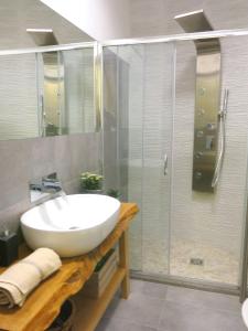 a bathroom with a sink and a glass shower at Pisetzky-Spadaro Apartments - Vegezio Roma in Rome