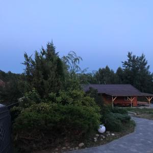 a house with a tree and a building at Domek na pensjonatowej 8 in Augustów