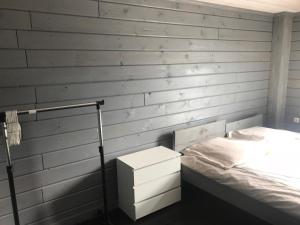 a bedroom with a bed and a white wall at Domek letniskowy in Augustów