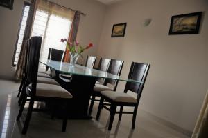 a dining room table with chairs and a vase of flowers at House of Traditions - Family Suite in Islamabad