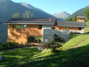 a house on a hill with mountains in the background at Chalet E Toue in Nendaz