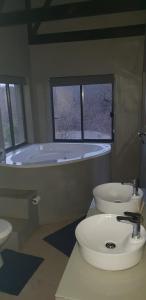 a bathroom with a tub and a toilet and a sink at Lionsview Private Lodge - 6 Lions in Marloth Park