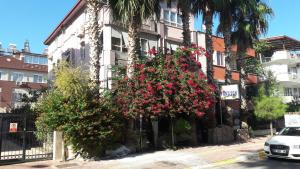 a building with red flowers in front of it at Gunay Pansiyon Antalya in Antalya