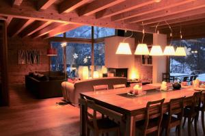 a living room with a wooden table and a living room with a couch at Chalet E Toue in Nendaz