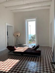 a white room with a bed and a checkered floor at PrimoPianoPosillipo in Naples
