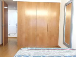 ein Schlafzimmer mit einem Holzschrank und einem Bett in der Unterkunft Maestro Appartment in Porto