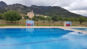 a large blue swimming pool with mountains in the background at Senda Caimari in Caimari