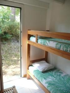 ein Etagenbettzimmer mit zwei Etagenbetten und einem Fenster in der Unterkunft Village Club Dunea in Soustons + 50 Fotos