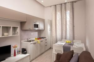 a kitchen and living room with a couch and a table at Well Done Montebello in Rome