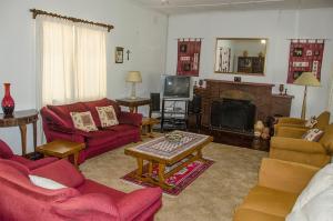 a living room with red furniture and a fireplace at Hillside Manor in Bulawayo