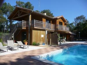 ein Haus mit einem Balkon und einem Pool in der Unterkunft Village Club Dunea in Soustons