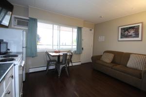 a kitchen and living room with a couch and a table at Harrison Spa Motel in Harrison Hot Springs