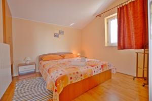 a bedroom with a bed and a window at Apartments Zora in Rakalj
