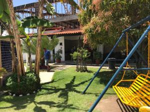a man standing in a yard with a swing at Residencial Madakaru - Chalé 14 in Porto De Galinhas