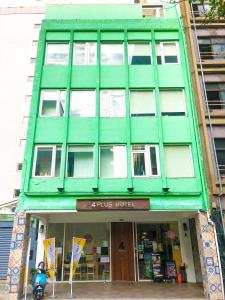 ein grünes Gebäude mit einem Laden davor in der Unterkunft 4Plus Hostel in Taipeh