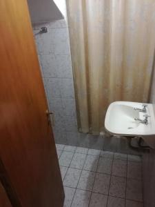 baño con lavabo y cortina de ducha en MIO NONNO MIA NONNA en San Clemente del Tuyú