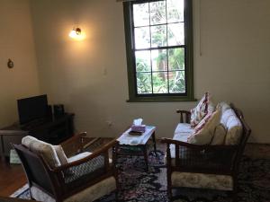 a living room with two chairs and a table at The Old School House in Te Awamutu