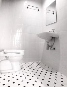 a white bathroom with a toilet and a sink at Rest Point Sampran in Nakhon Pathom