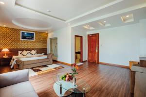 a living room with a bed and a table at Nesta Hotel Phu Quoc in Phu Quoc