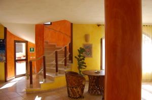 a living room with a staircase and a table and a room at El Mosaico Del Sol in Lampedusa