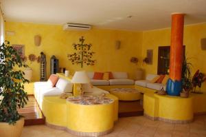 a living room with yellow walls and couches at El Mosaico Del Sol in Lampedusa