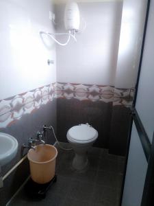 Hotel Gopi Palace في أحمد آباد: حمام مع مرحاض وحوض استحمام بجوار حوض
