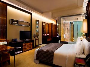 a hotel room with a bed and a television at The Fullerton Bay Hotel Singapore in Singapore