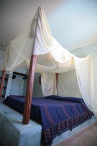 a bedroom with a bed with a canopy at El Mosaico Del Sol in Lampedusa