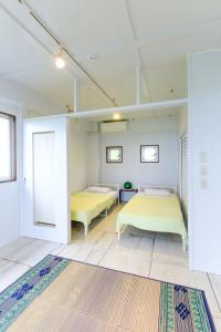 石垣島にあるamber moonの白い壁の部屋にベッドが2つある