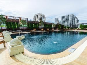 a swimming pool with a fountain in a city at Centre Point Sukhumvit 10 - SHA Extra Plus in Bangkok